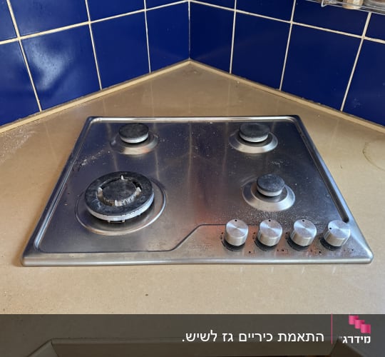 כיריים על משטח שיש במטבח עם אריחים כחולים
